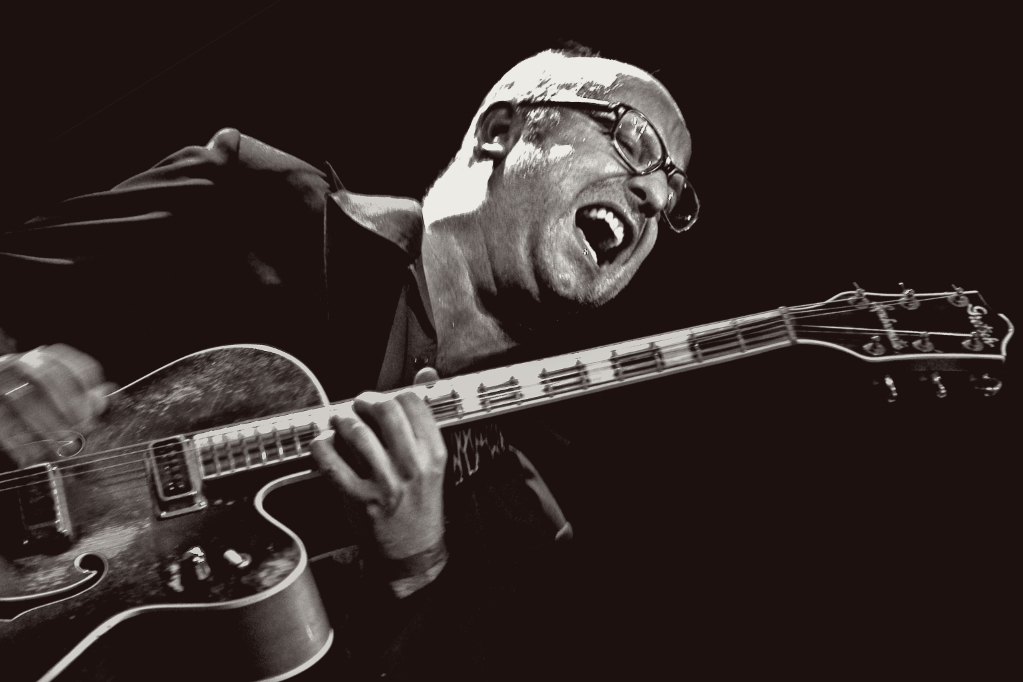 stylish duotone photo of Anton Goudsmit with a transparent guitar image behind him